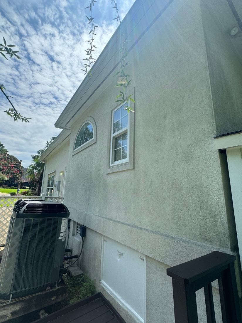 Stucco house wall with green streaks, ready for a soft wash